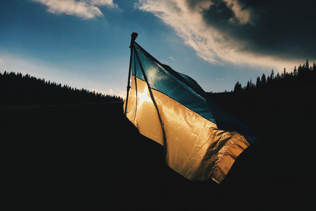 A Ukrainian flag back lit by the sun.