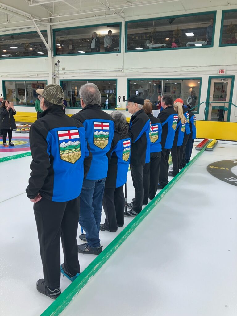 Curling team lined up for the anthem.