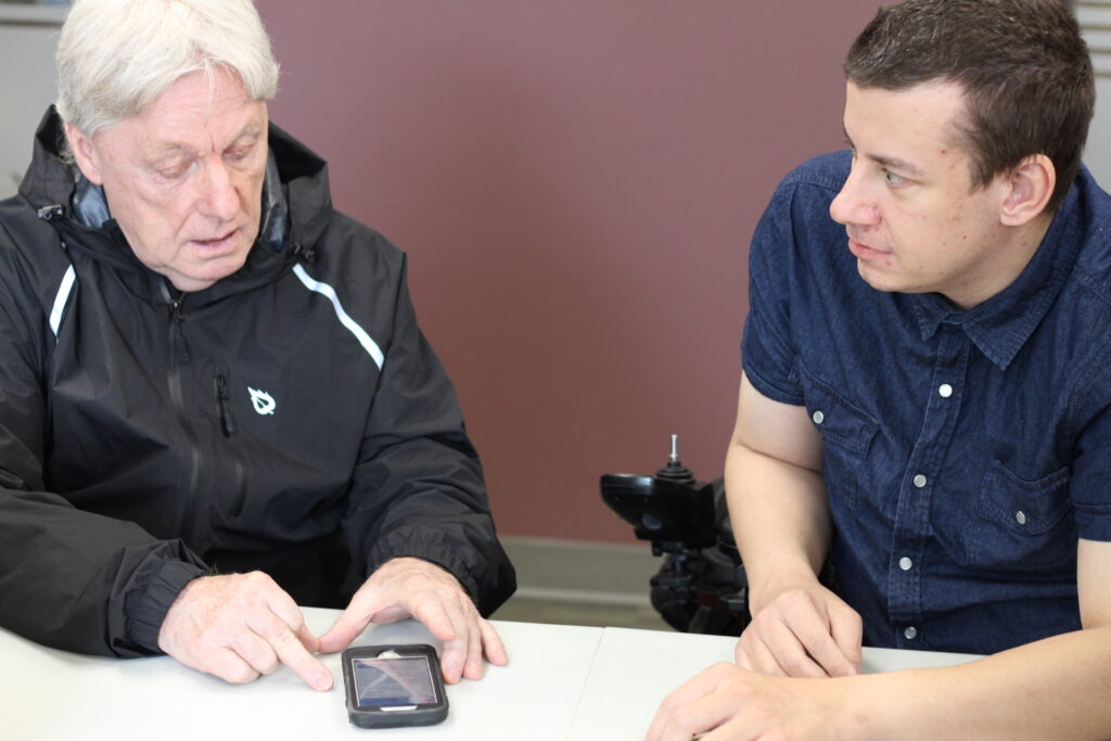 A CCB GTT mentor helping a client use a smartphone.