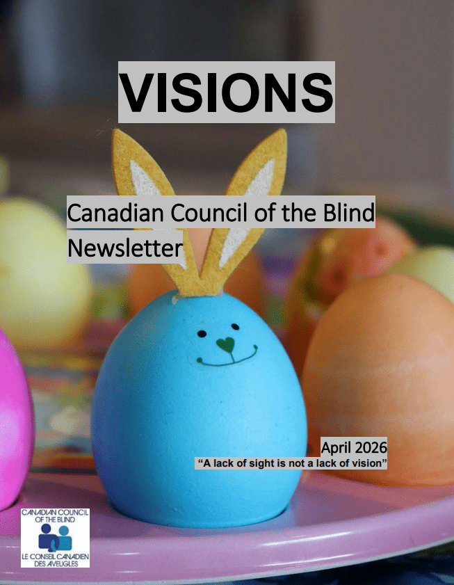 Closeup of a smiling blue Easter egg with a green heart-shaped nose and mouth, and brown and white bunny ears attached to the top. In the blurred background are several other colourful Easter eggs. They all sit above a pink plate.
